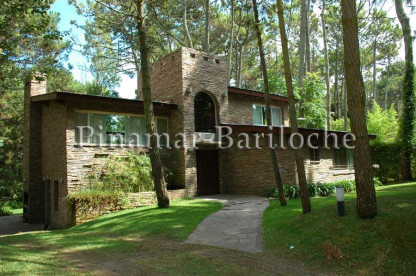 Fachada de amplia casa en alquiler en Cariló, rodeada de bosque, ideal para familias o grupos de hasta 14 personas. Frente de la casa en alquiler en Cariló parque y explanada para autos.