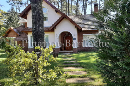 Frente de una casa en alquiler en Cariló, rodeada de bosque y jardín, con un dormitorio en planta baja, parrilla y capacidad para 6 personas. Ideal para vacaciones en familia. Parque y frente de la propiedad en alquiler dueño directo en Cariló.