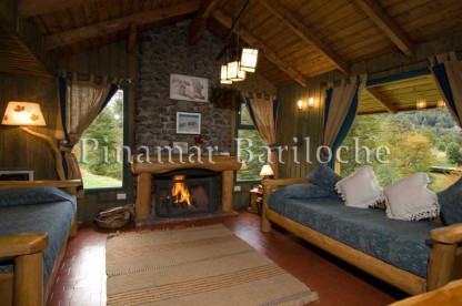 Ambiente de cabaña en alquiler dentro de complejo con servicios en Lago Gutierrez. Living con hogar encendido de cabaña en Lago Gutierrez Bariloche