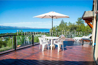 Casa en alquiler con vista al lago en Bariloche, gran deck de madera. Capacidad 12 personas. Gran deck con mesa y reposeras con vista al lago en Bariloche