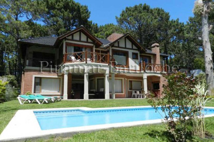 Casa en venta directa zona Golf en Pinamar, 4 dormitorios, dependencia, galería, parrilla y pileta. Piscina, parque y fachada de casa al golf en Pinamar