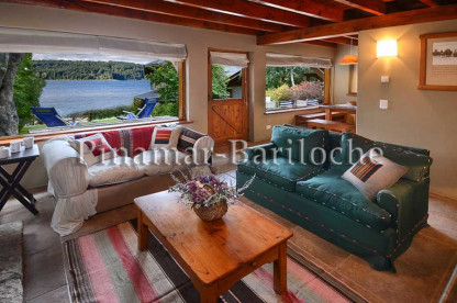 Complejo de cabañas en alquiler temporario en Bariloche junto al Nahuel Huapi. Cabaña en alquiler en Bariloche junto al lago cómodo living con ventanales.
