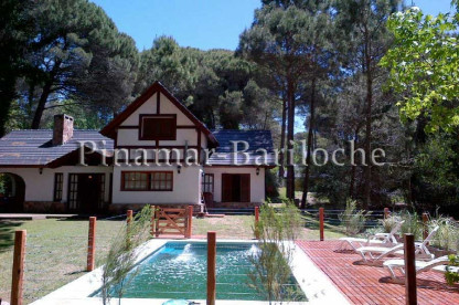 Exterior de la casa en alquiler en Cariló con pileta climatizada cercada, amplio parque, 4 dormitorios y capacidad para 9 personas. Ideal para vacaciones en familia. Vista desde la pileta climatizada y cercada de la casa en Cariló.