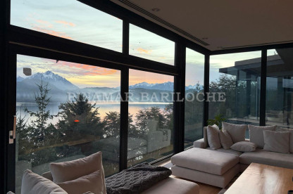 Living con grandes ventanales al lago