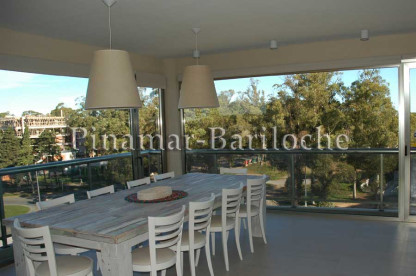 Comedor luminoso con vista abierta en departamento con amenities y capacidad para 6 personas. Edificio con amenities. Comedor con amplios ventanales de departamento en alquiler en Pinamar