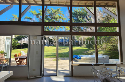 Amplio living con grandes ventanales y vista al jardín de una casa en alquiler en Cariló. Living con vista al parque en casa en alquiler en Cariló