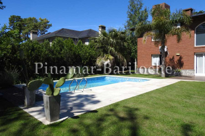 Vista exterior de la casa en alquiler temporario en Pinamar con pileta climatizada, amplio jardín y solárium, ubicada cerca de los balnearios Cocodrilo y Perico. Pinamar Casa en alquiler barrio Álamos, con pileta climatizada