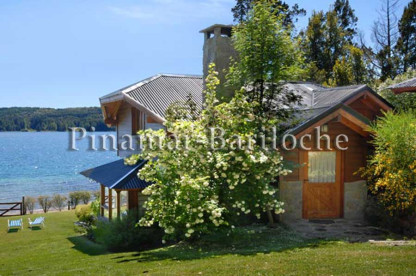 Cabaña con capacidad para 8 personas dentro de complejo con costa de lago. Vista del parque, cabaña y costa de lago de la cabaña en Bariloche.