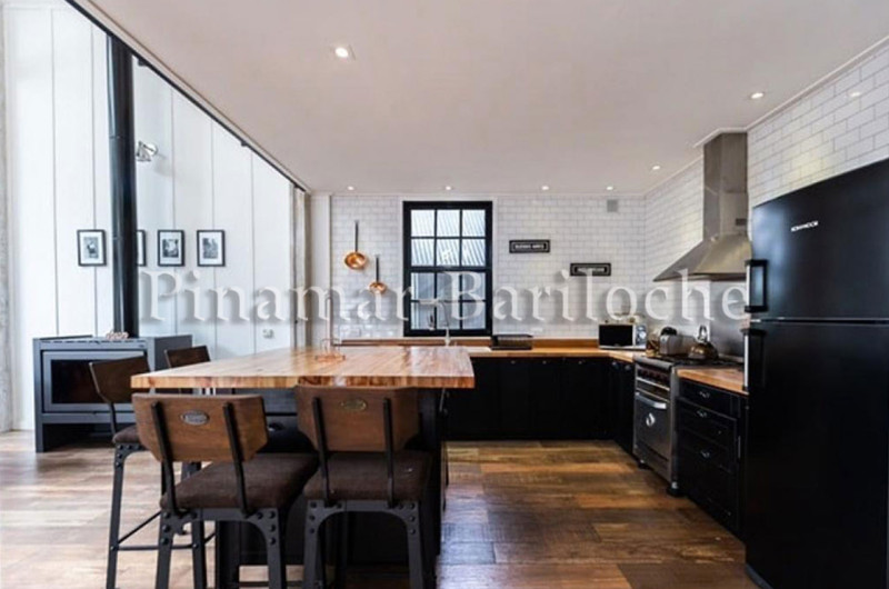 Cocina abierta con barra y butacas.