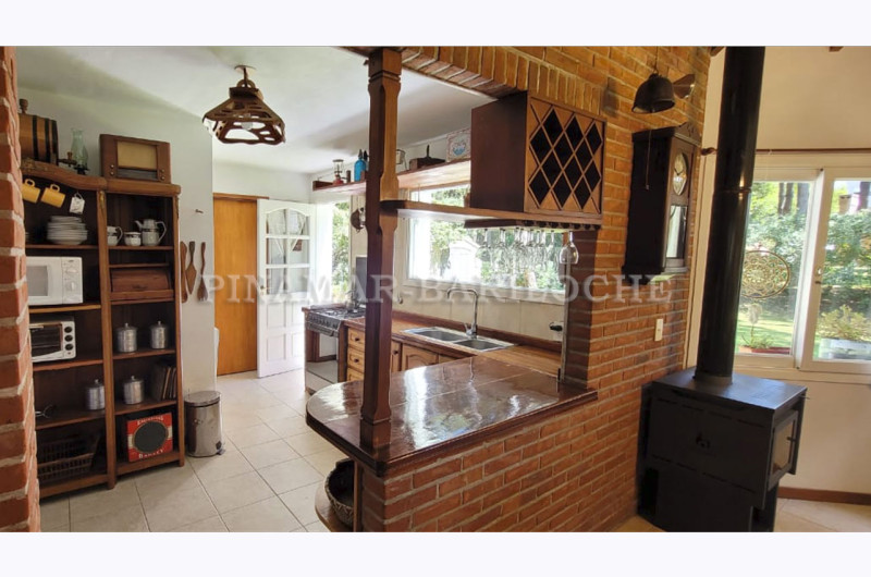 Cocina abierta con pasa platos y acceso directo al exterior.
