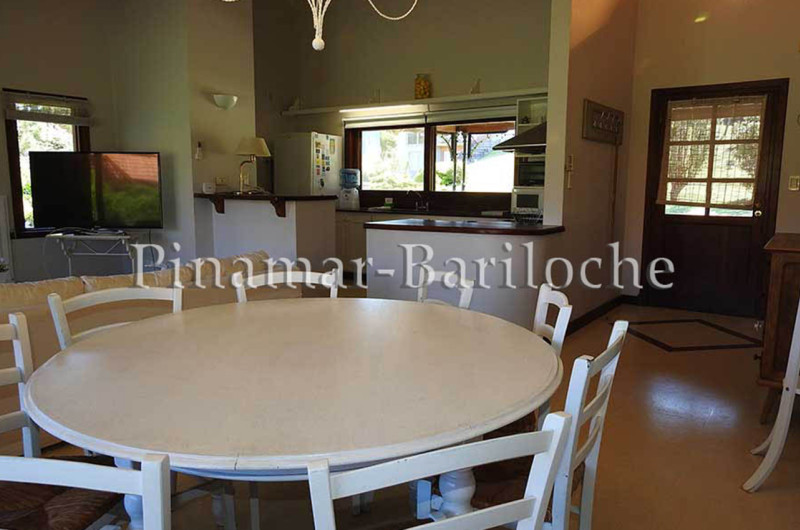 Mesa de comedor con vista a cocina incorporada.
