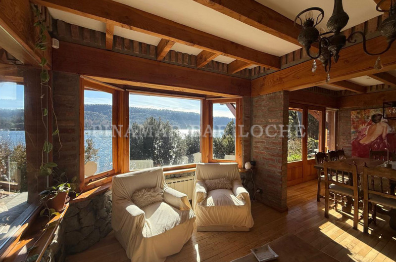 Sector de estar y comedor integrado, con amplios ventanales y vista al lago.