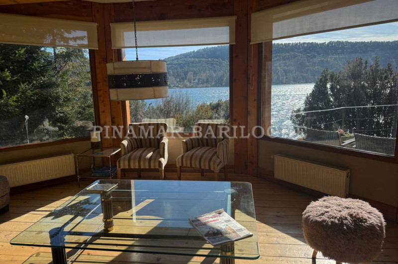 Living con grandes ventanales al lago.