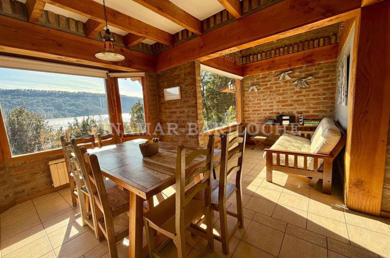 Otra distribución del comedor y sector de estar, con vista panorámica al lago.