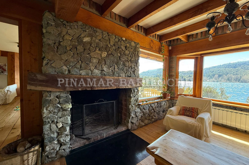 Estufa hogar revestida en piedra, ambiente con vista al lago.