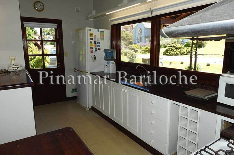 Cocina completa con grandes ventanales y puerta de acceso exterior.